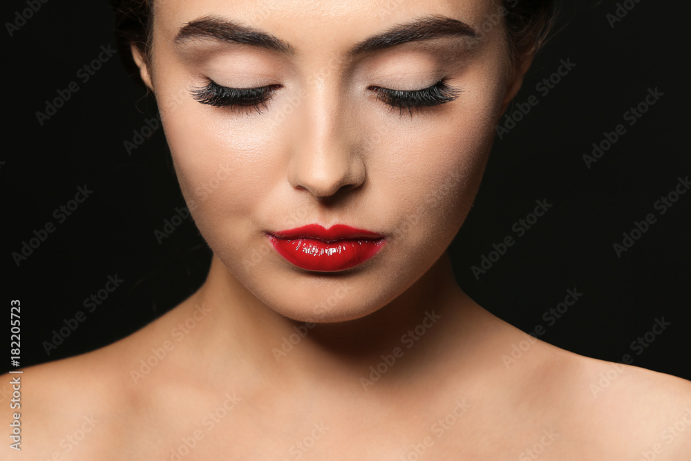 Beautiful young woman with eyelash extensions on dark background Beautiful young woman with eyelash extensions on dark background