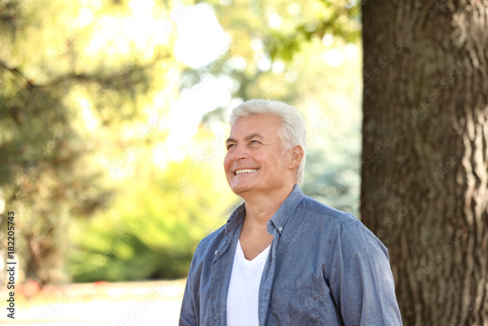 Handsome mature man near tree in park Handsome mature man near tree in park