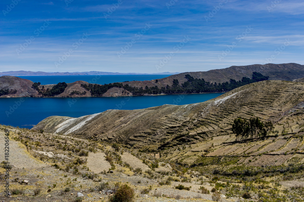 View across La isla del Sol with blue Sky water and trees Lake T View across La isla del Sol with blue Sky water and trees Lake T