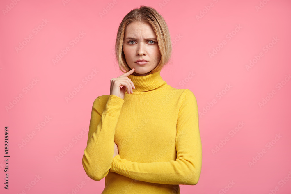 Sad discontent female has unhappy and tired look, poses against pink background, being fatigue after long exhausted trip, rest at home enjoys domestic atmosphere. Miserable woman has gloomy expression Sad discontent female has unhappy and tired look, poses against pink background, being fatigue after long exhausted trip, rest at home enjoys domestic atmosphere. Miserable woman has gloomy expression