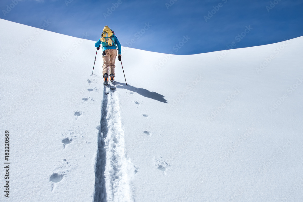 A skier walks in the mountains