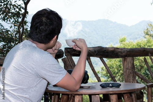 Freedom time of happy young Asian man sitting and looking at beautiful nature.