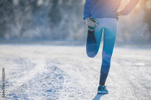 Runner stretching in winter Park. A healthy way of life.
