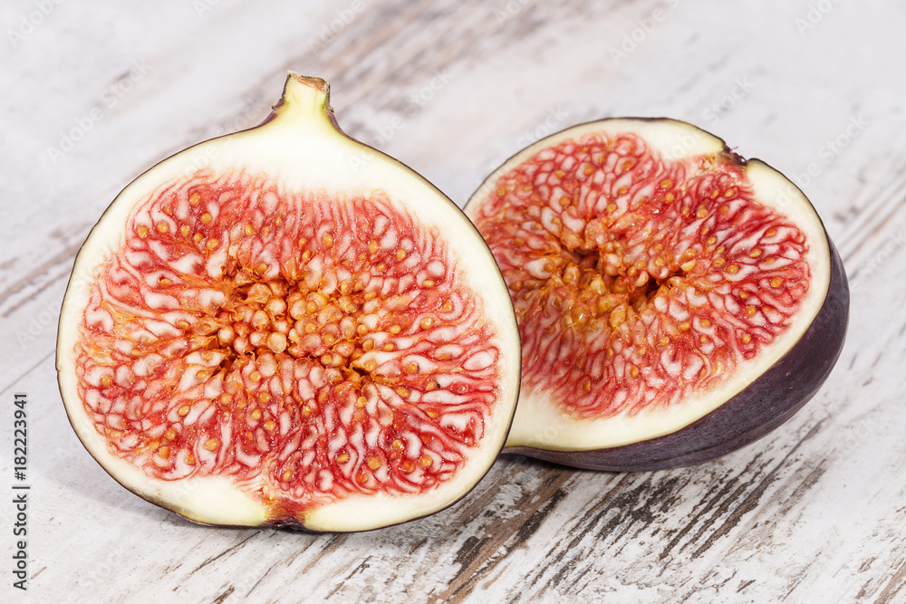 Fruits of half fresh figs on wooden plank, close up. Fruits of half fresh figs on wooden plank, close up.