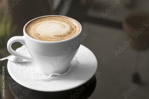 White mug with coffee. A fragrant cappuccino. An unusual tinted photograph with a bokeh.
