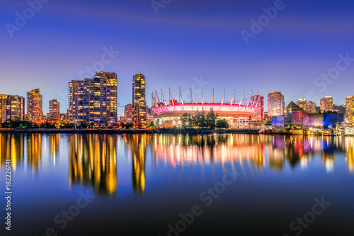 The night life of a huge seaside city with modern brilliant multicolored neon lights of skyscrapers, quaint ultra-modern office and residential buildings