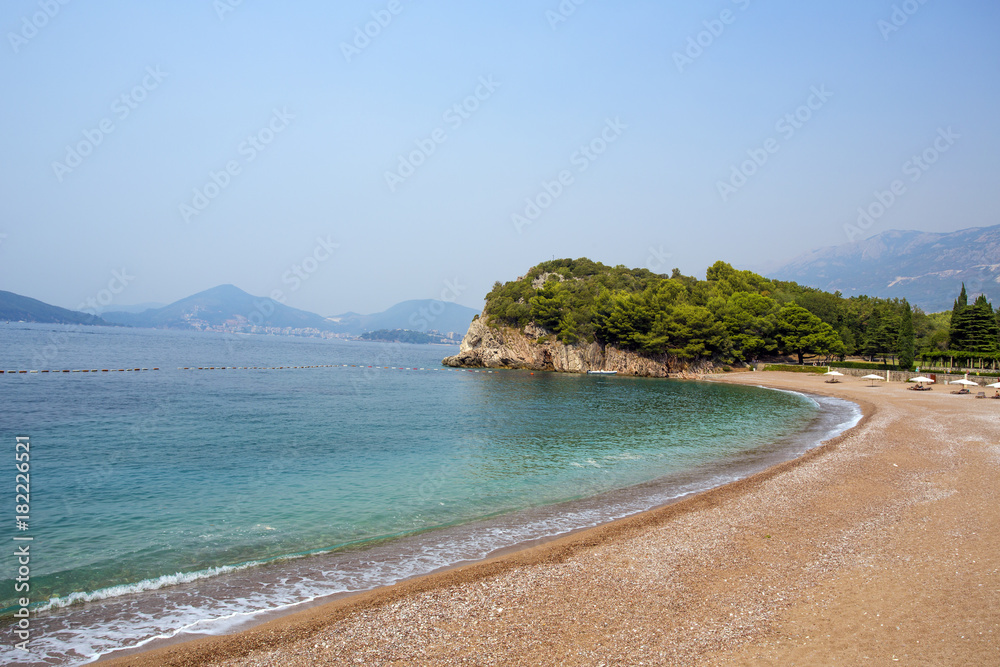 A deserted sandy beach among the beruze water.