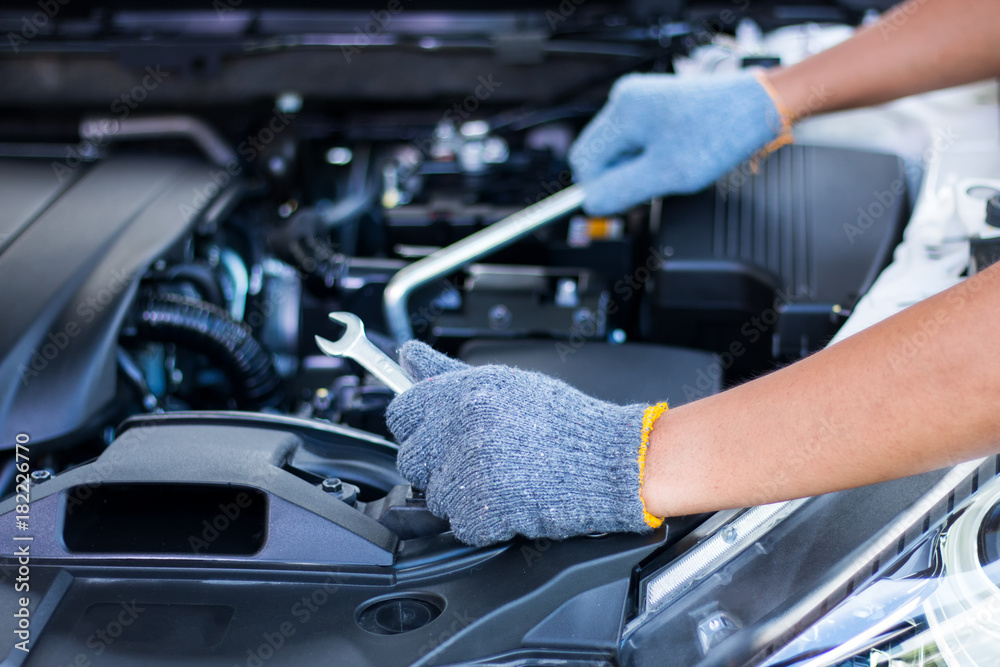 Car mechanic with wrenchCar mechanic repairing a car engine