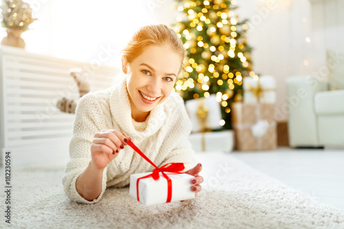 happy woman with gift at morning near Christmas tree