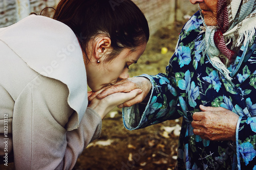 Granddaughter kisses old hands of his grandmother