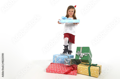 Kleines M  dchen mit Weihnachtsm  tze steht zwischen Geschenken
