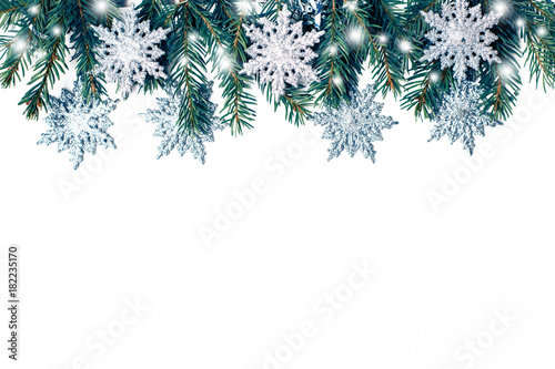 Christmas composition of fir branches and snowflakes on a white background isolated