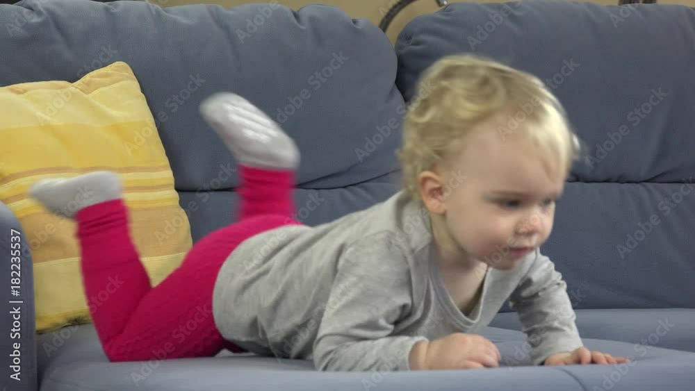 Little baby girl climbing off blue sofa and walk away at home. Little baby girl climbing off blue sofa and walk away at home.