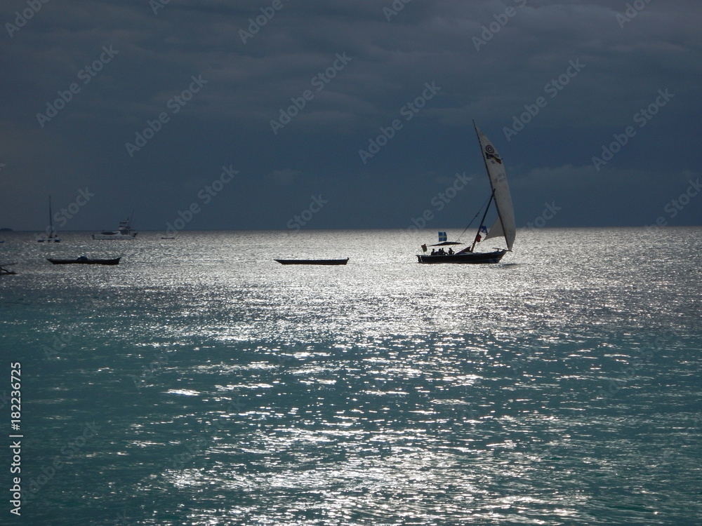 Naklejka premium romantic sunset with a boat on the ocean