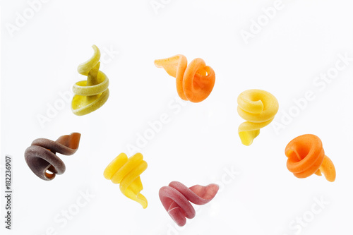 Multi-colored pasta isolated on white background flying in the air