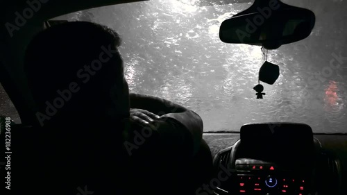 The driver waits in the car when the rain ends. Black and white photo