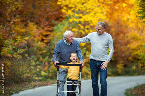 Konstfotografi Elderly father adult son and grandson out for a walk in the park.
