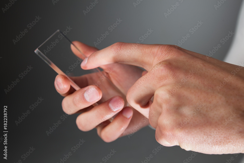 Hands holding futuristic transparent phone Hands holding futuristic transparent phone