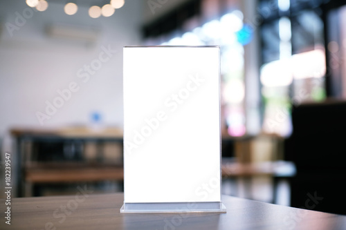 Mock up Menu frame standing on wood table in Bar restaurant cafe. space for text.