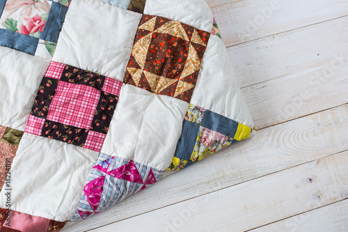 Part of color patchwork quilt as white wooden background. Colorful blanket in style patchwork close up. Handmade.