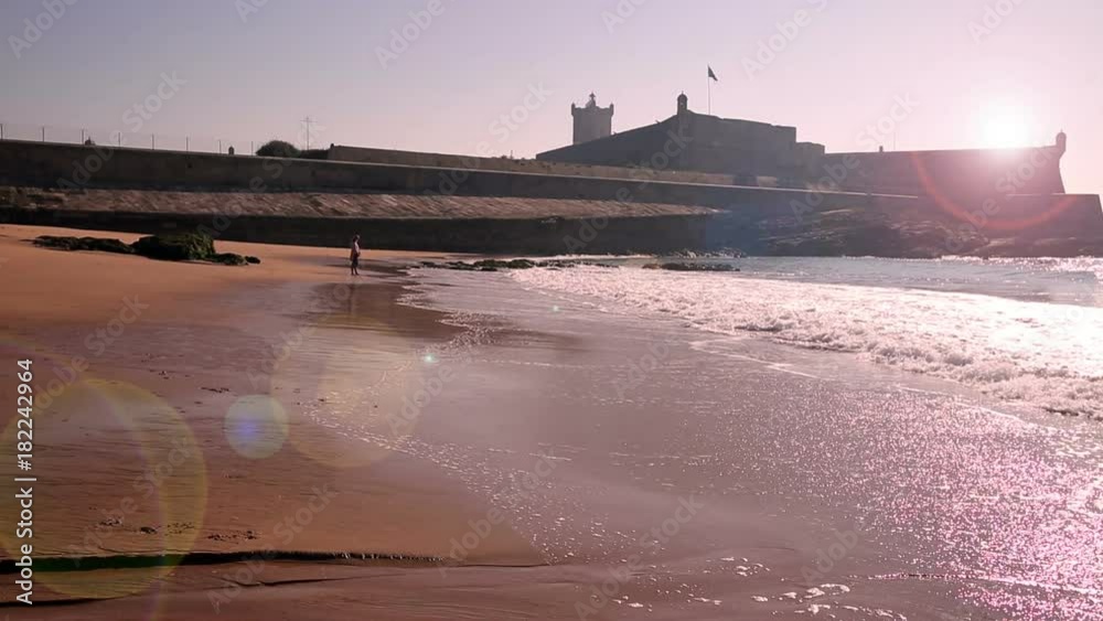 sunset with a lens flare at Carcavelos beach, Lisbon, Portugal