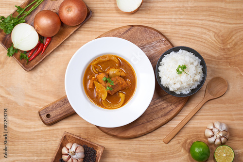 spicy chicken and rice on wooden background