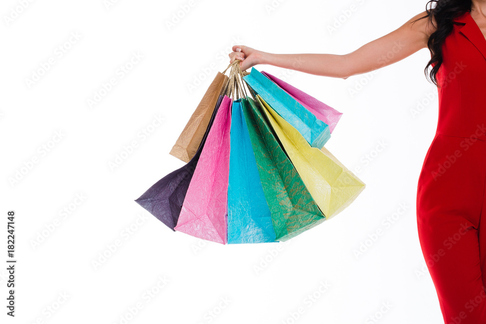 Heavy shopping bags! Part of young woman holding shopping bags while standing against white background