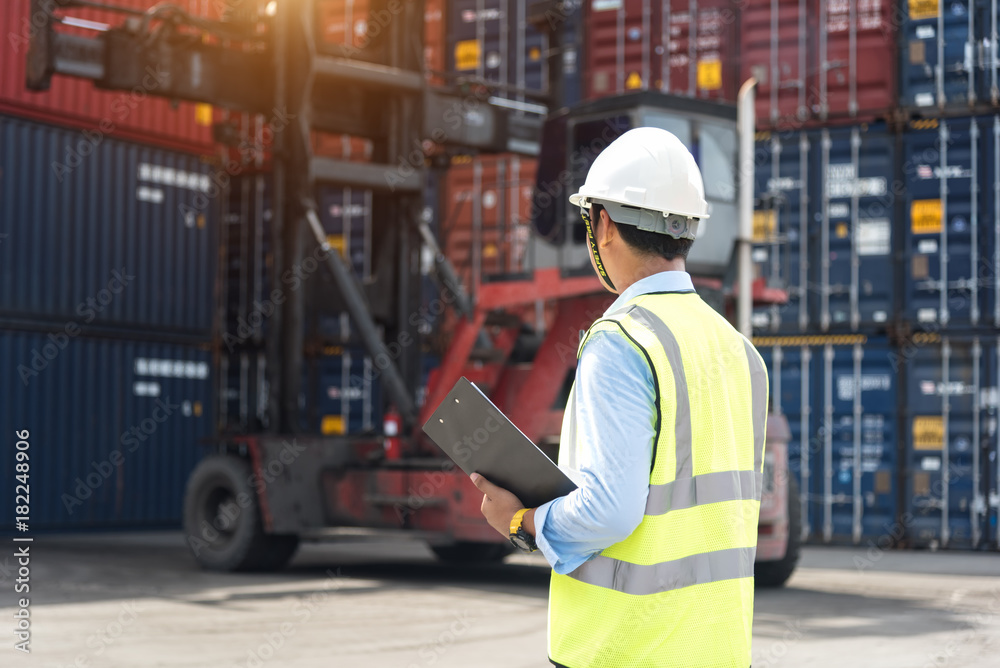 Foreman control loading Containers box from Cargo freight ship