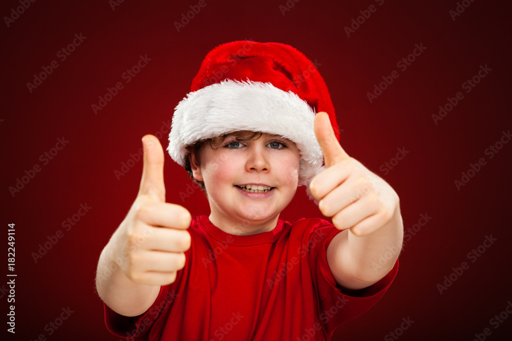 Christmas time - boy with Santa Claus Hat showing OK sign Christmas time - boy with Santa Claus Hat showing OK sign