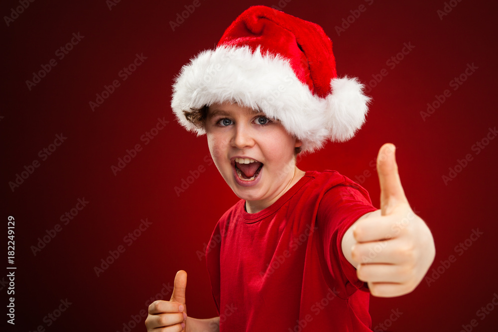 Christmas time - boy with Santa Claus Hat showing OK sign Christmas time - boy with Santa Claus Hat showing OK sign