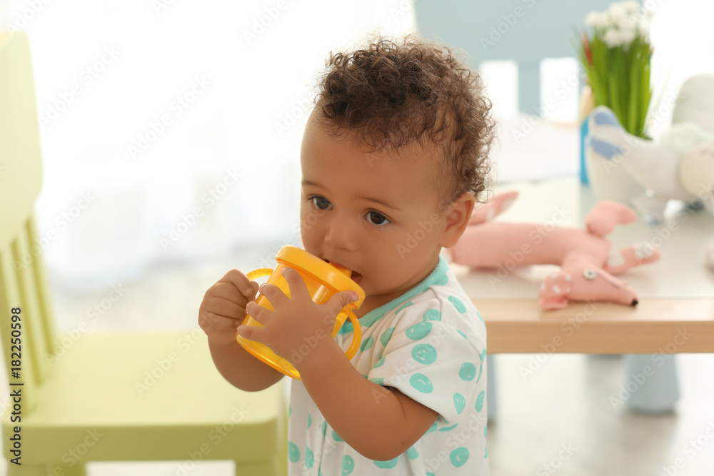 Cute baby with bottle of water indoors Cute baby with bottle of water indoors