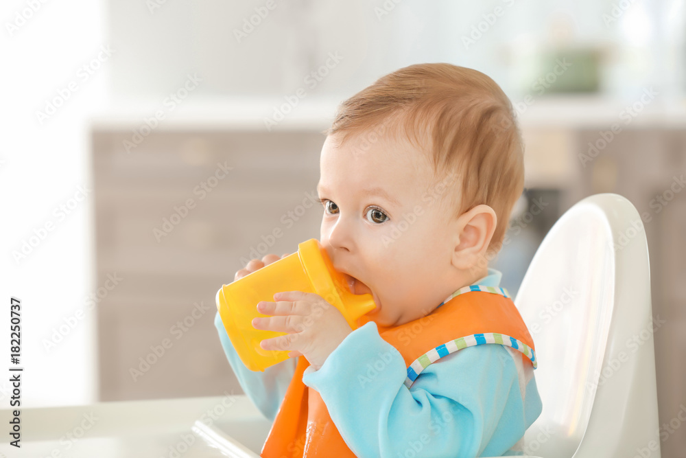 Cute baby drinking water in kitchen Cute baby drinking water in kitchen