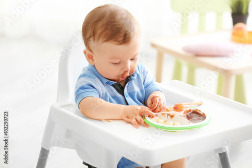 Cute messy baby eating pure...