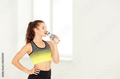 Sporty young woman drinking...