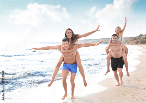 Group of young people playing on beach © Africa Studio