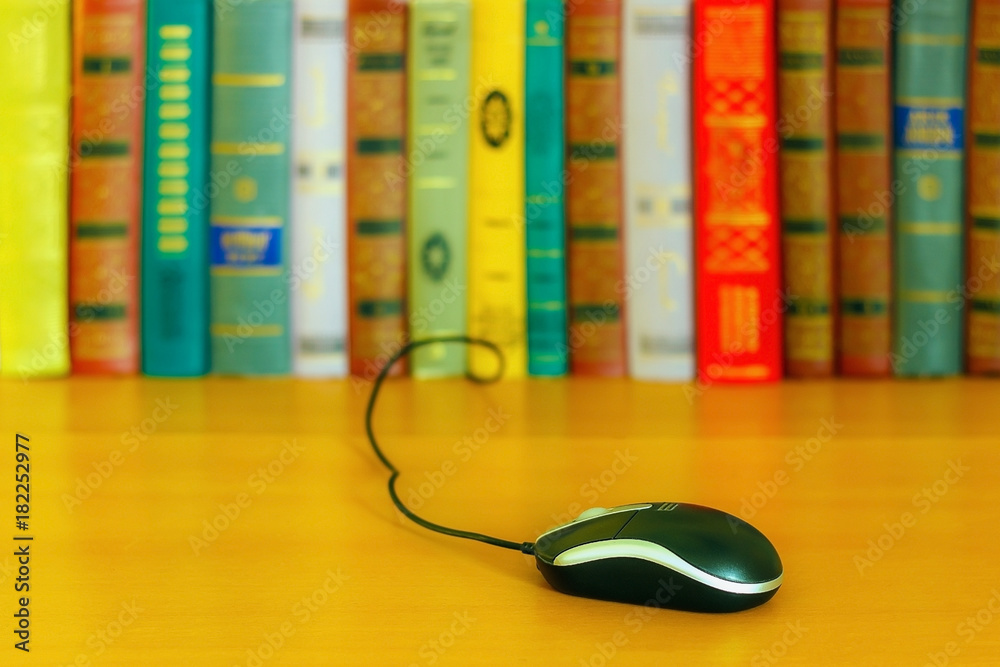 on the table a number of books and a mouse from the laptop. on the table a number of books and a mouse from the laptop.