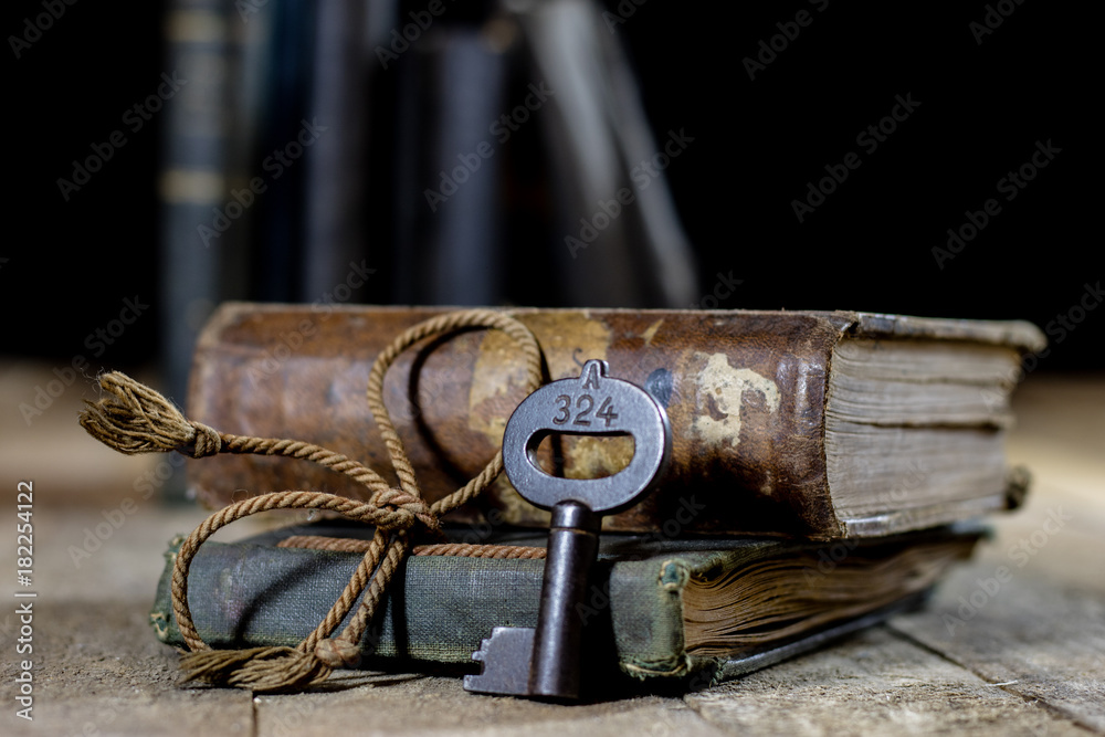 Very old book and key on an old wooden table. Old room, wooden table and book with key.