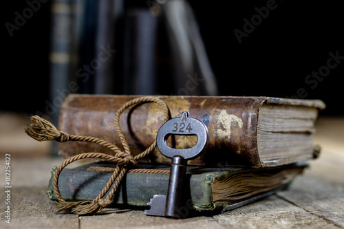 Very old book and key on an old wooden table. Old room, wooden table and book with key.
