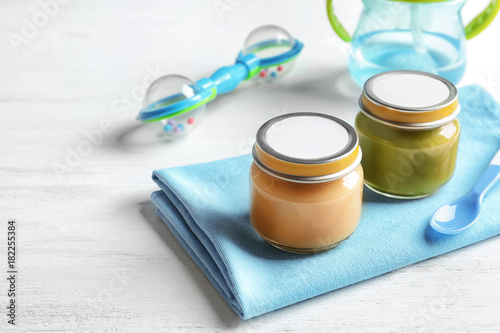 Jars with healthy baby food on wooden table