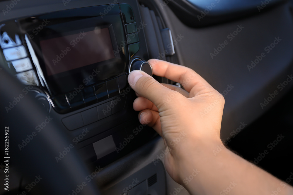 Man tuning car radio, closeup