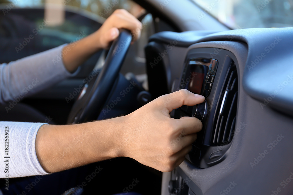 Man tuning car radio, closeup