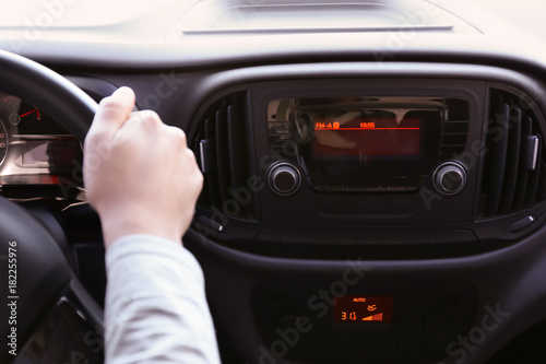 Man driving car while listening to radio