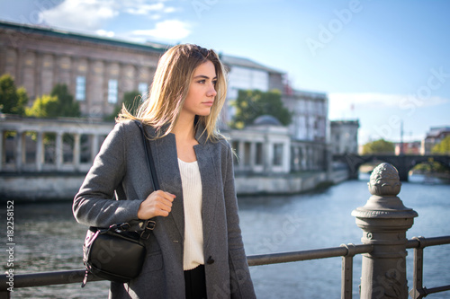 Beautiful woman standing on city embankment and enjoying the view.