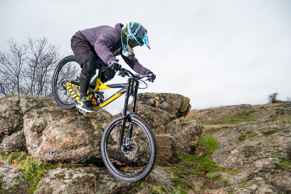 Professional Cyclist Riding Mountain Bike Down the Rocky Hill. Extreme Sport and Enduro Biking Concept. Professional Cyclist Riding Mountain Bike Down the Rocky Hill. Extreme Sport and Enduro Biking Concept.