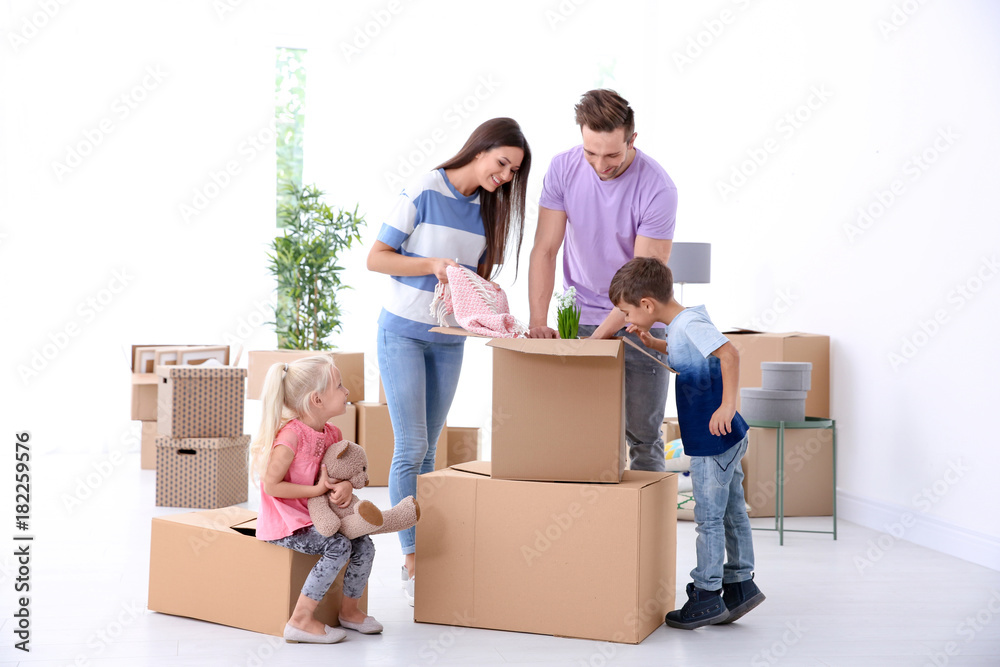 Happy family unpacking boxes in their new home Happy family unpacking boxes in their new home