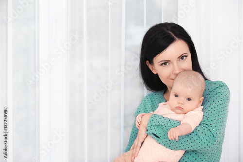 Young mother and cute baby at home