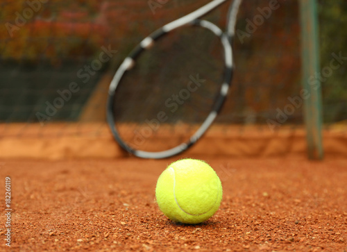 Tennis ball and blurred racket on court