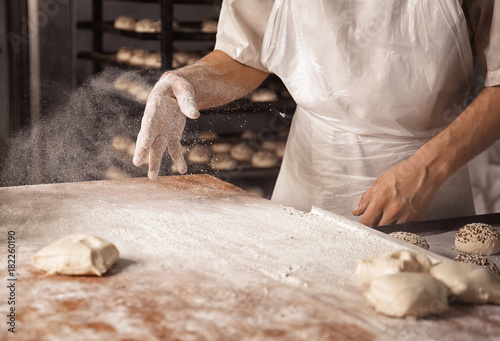 Man preparing buns in bakery