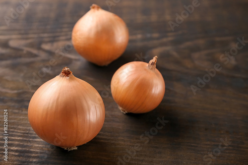 Fresh raw yellow onion on wooden background