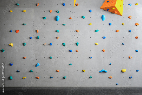 Grey wall with climbing holds in gym